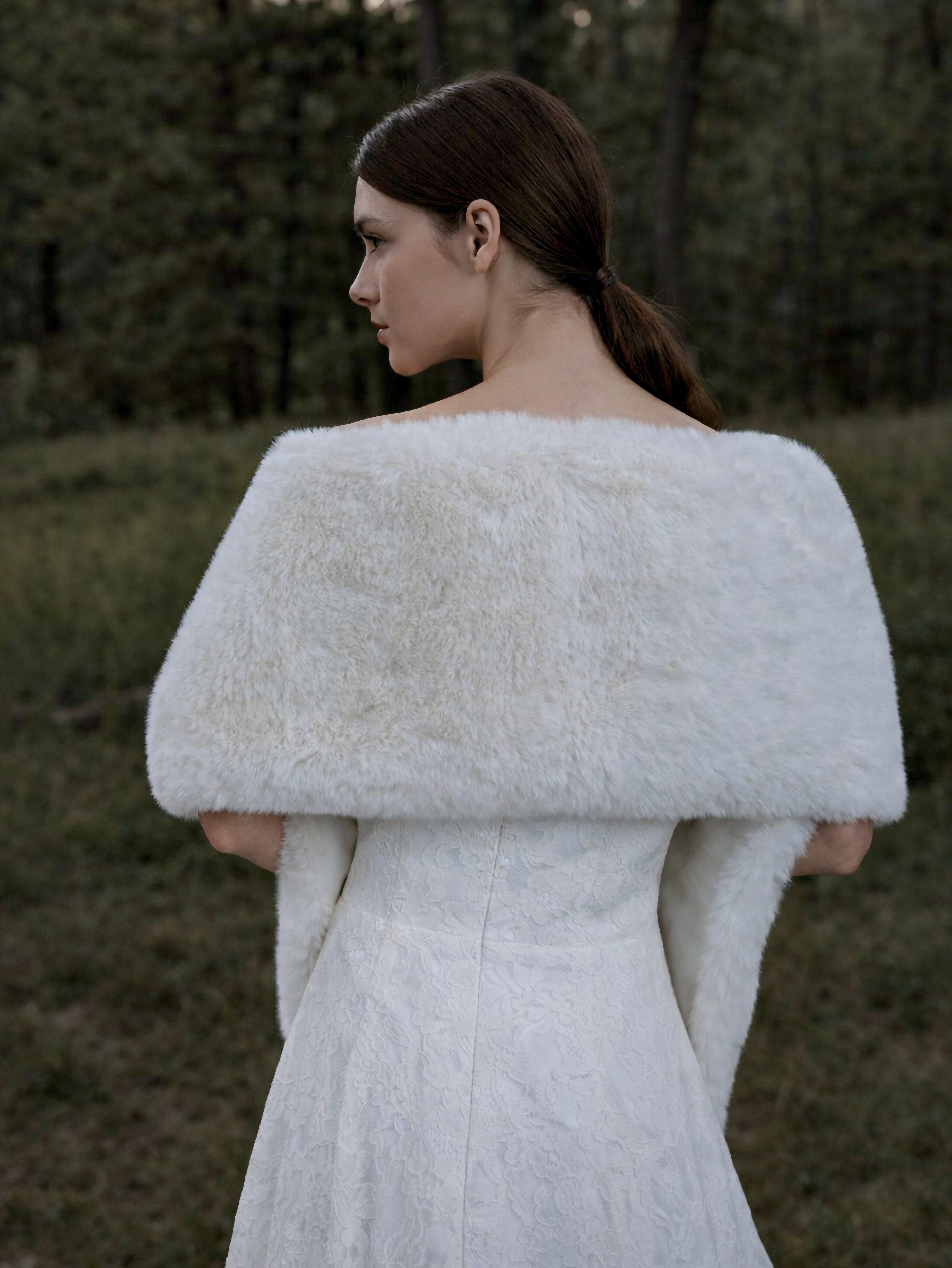 Back view of ivory white faux fur bridal wrap styled over lace wedding dress.
